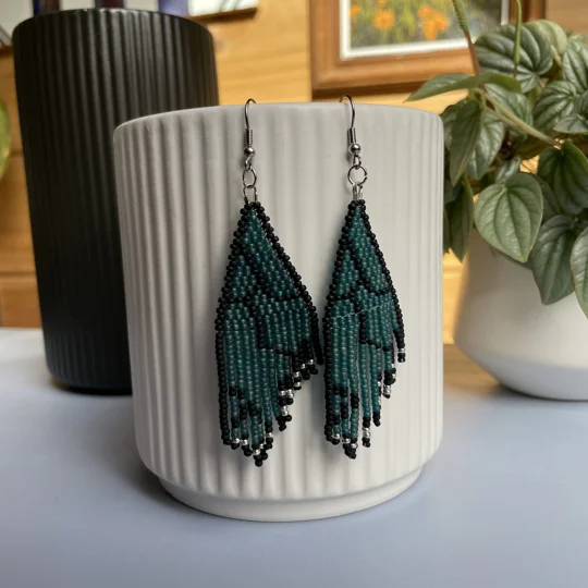 Unique earrings feature intricate beadwork, capturing the delicate charm of butterfly wings in vibrant frosted blue that glows in the sunlight