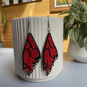 Unique earrings feature intricate beadwork, capturing the delicate charm of butterfly wings in vibrant red