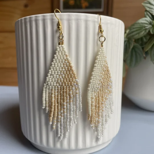 A pair of handmade beaded fringe earrings. Colors in a gradient antique whites