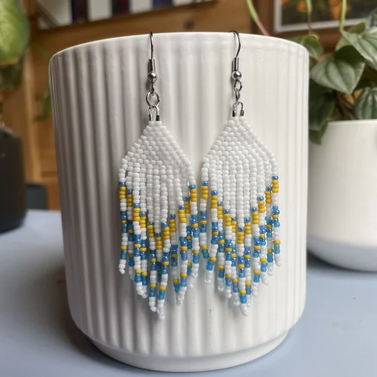 captivating chevron shapes, exuding a sense of dynamic movement and modern flair.  
white, blue, and yellow beads