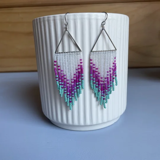 These distinctive earrings seamlessly blend geometric precision with a touch of cool sophistication. The silver triangles add a contemporary edge, while the colored beads infuse a subtle pop of color, creating a unique and eye-catching accessory.

frosted white, magenta, aqua