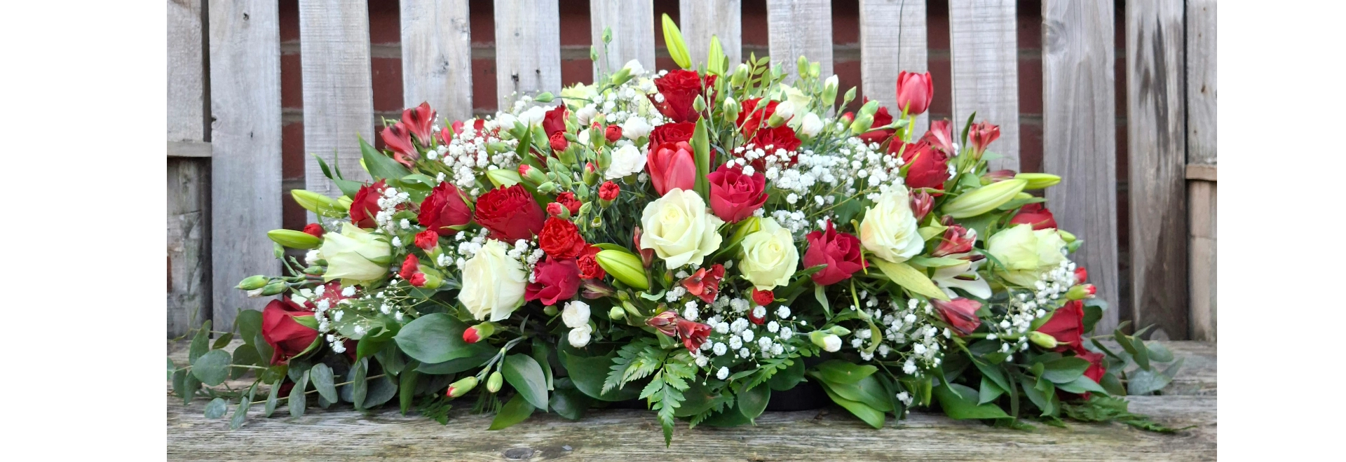 Funeral casket spray front view handcrafted with red and white flower colours