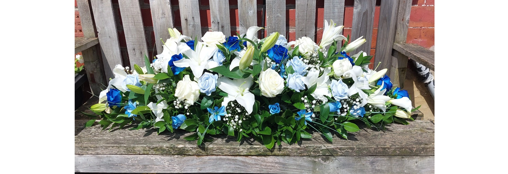 casket spray side view made with blue and white flowers