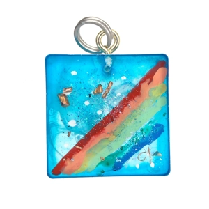 Reiki charged handmade pendant rainbow against a blue sky